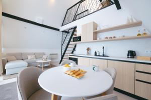 a kitchen and living room with a white table and chairs at De Villa Bey in Kupres