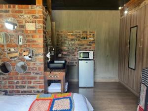 a room with a brick wall and a kitchen with a sink at Bolt in Gaborone