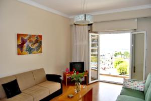 uma sala de estar com um sofá e uma televisão em Maria's House em Kavala
