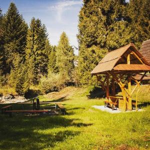 a gazebo with a picnic table in the grass at Ośrodek Nad Potokiem in Poręba Wielka +10 photos