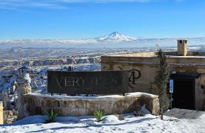 a sign in the snow with a view of a mountain at Very Peri Cappadocia - The Lifestyle Luxury Design Hotel in Uçhisar