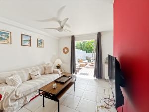 a living room with a white couch and a tv at Mango Rouge, 2 bedrooms & pool in Saint Martin