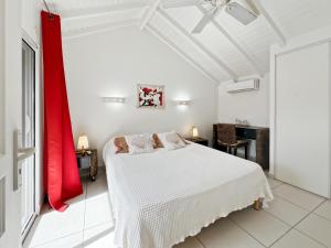 a bedroom with a white bed and a red curtain at Mango Rouge, 2 bedrooms & pool in Saint Martin +22 photos
