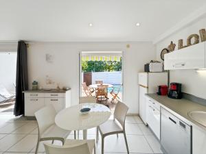 a kitchen with a table and chairs and a table at Mango Rouge, 2 bedrooms & pool in Saint Martin