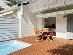 a patio with a table and chairs on a deck at Mango Rouge, 2 bedrooms & pool in Saint Martin