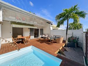 a backyard with a wooden deck and a swimming pool at Mango Rouge, 2 bedrooms & pool in Saint Martin