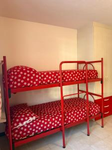 two red bunk beds with polka dot sheets at Chalet Nonno Ezio in Valdidentro