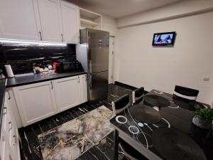 a kitchen with a table and a refrigerator at Enjoy VIP House 10 in Măgurele