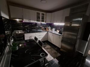 a kitchen with white cabinets and a black refrigerator at Enjoy VIP House 10 in Măgurele +26 photos