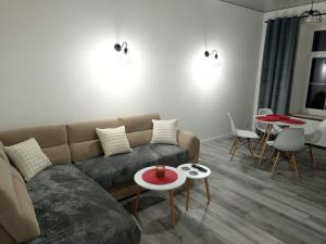 a living room with a couch and tables at Beti's Apartment in Zambrów