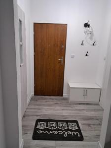 a hallway with a door and a rug on the floor at Beti's Apartment in Zambrów
