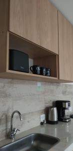 a kitchen counter with a sink and a microwave at Duplex Atenea in Chivilcoy