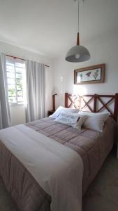 a bedroom with a large bed with white sheets at Duplex Atenea in Chivilcoy