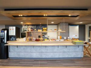a kitchen with a counter with food on it at ibis budget Rennes Chantepie - Hôtel rénové in Chantepie