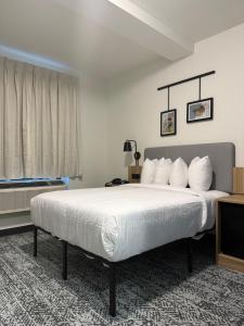 a bedroom with a large bed with white sheets at Sleep Inn in Brooklyn