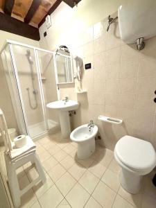 a white bathroom with a toilet and a sink at Residenza Le Logge in Gubbio