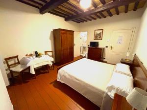a bedroom with two beds and a table and a chair at Residenza Le Logge in Gubbio
