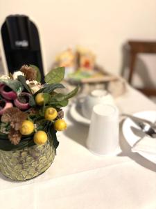 a vase filled with fruit on top of a table at Residenza Le Logge in Gubbio +39 photos