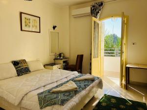 a bedroom with a large bed and a balcony at Amon Hotel in Luxor +98 photos