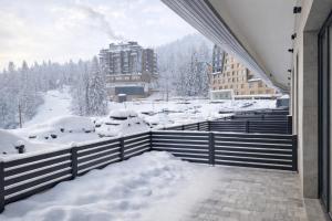 a view from a balcony of a snow covered city at Mountain View -ski & mountain retreat, Apartment 01 PRIZEMLJE u Premium objektu in Jahorina