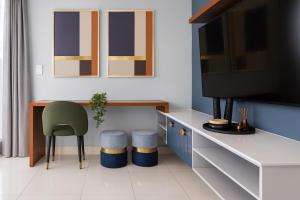 a living room with a tv and a chair at Confortable Apartamento Centro Ciudad in Santo Domingo