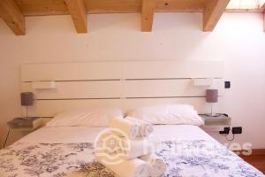 a bedroom with two beds with white sheets and two lamps at Appartamento Ad Navalia in Varazze