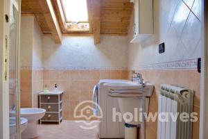a bathroom with a refrigerator and a toilet and a sink at Appartamento Ad Navalia in Varazze
