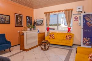 a living room with a yellow couch and a window at Hotel Posada Stella Maris in Puerto Barrios