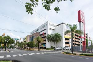 a city street with a building and palm trees at Confortable Apartamento Centro Ciudad in Santo Domingo
