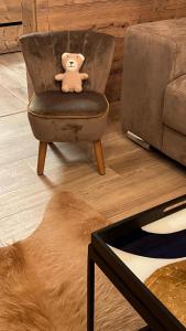 a teddy bear sitting on a chair in a living room at Apartments Panorama Donovaly in Donovaly