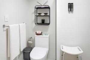 a white bathroom with a toilet and a sink at Confortable Apartamento Centro Ciudad in Santo Domingo +8 photos