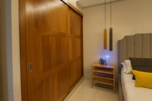 a bedroom with a wooden door next to a bed at Confortable Apartamento Centro Ciudad in Santo Domingo