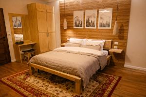 a bedroom with a large bed with a wooden wall at Chalet Village Bran in Bran