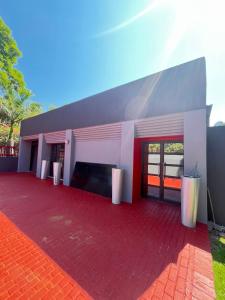 a house with a red brick patio with a fireplace at Beyond Borders Guest House in Polokwane