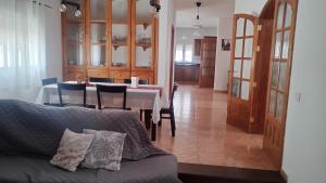 a living room with a couch and a table with chairs at LA CALDERETA CASA RURAL in La Oliva