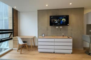 a room with a white dresser and a tv on a wall at Mitik Vista iluminación y comodida in Bogotá
