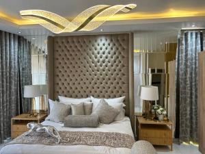 a bedroom with a large bed with a large headboard at Beyond Borders Guest House in Polokwane +95 photos