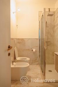 a bathroom with a toilet and a sink and a shower at La casa di Luisa in Moneglia