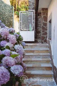 a staircase with purple flowers in front of a window at La casa di Luisa in Moneglia +41 photos