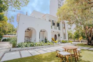 a white house with a table and chairs in the yard at Flor De India in San Juan