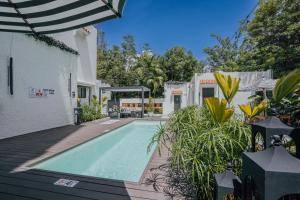 a swimming pool in front of a white house at Flor De India in San Juan