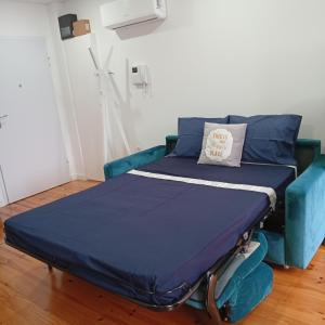 a bed in a room with a blue couch at Dolce Vita Heroismo in Porto