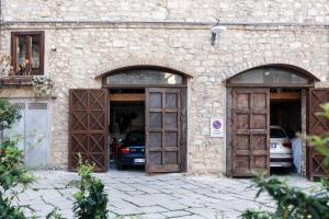 a building with two doors and a car parked in it at La suite del convento in Potenza
