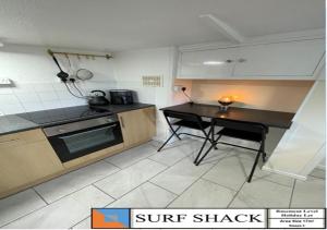a kitchen with a counter and a table in it at Beckington House in Braunton +4 photos