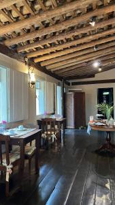 a large room with wooden ceilings and tables and chairs at Pousada Casagrande in Pirenópolis