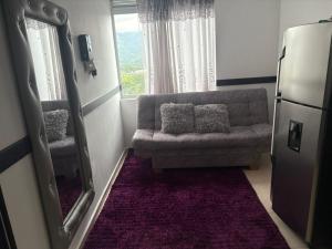 a living room with a couch and a window at apta estudio oronegro amanecer in Armenia
