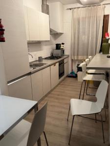 a kitchen with white cabinets and a table and chairs at Sun Moon Venice Harrysclass in Venice +31 photos
