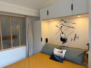 a bedroom with a bed with a painting on the wall at Charmant duplex Proche station in Aime-La Plagne