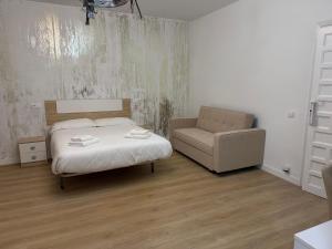 a bedroom with a bed and a chair at Hostal Gran Capitán in Toledo