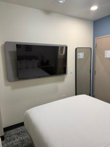 a bedroom with a bed and a flat screen tv on the wall at Sleep Inn in Brooklyn +21 photos